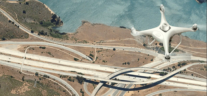 Construction drone hovering over a field of roadtracks.